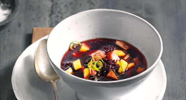 Consommé von schwarzem Reis mit Hummer und Mango