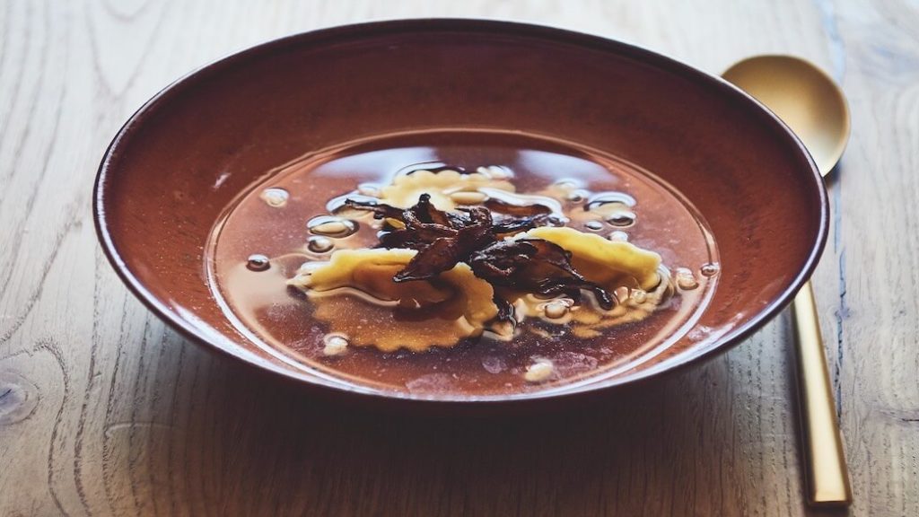 Shiitake-Bouillon mit Auberginen-Tortellini und Pinienkernen