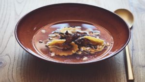 Shiitake-Bouillon mit Auberginen-Tortellini und Pinienkernen